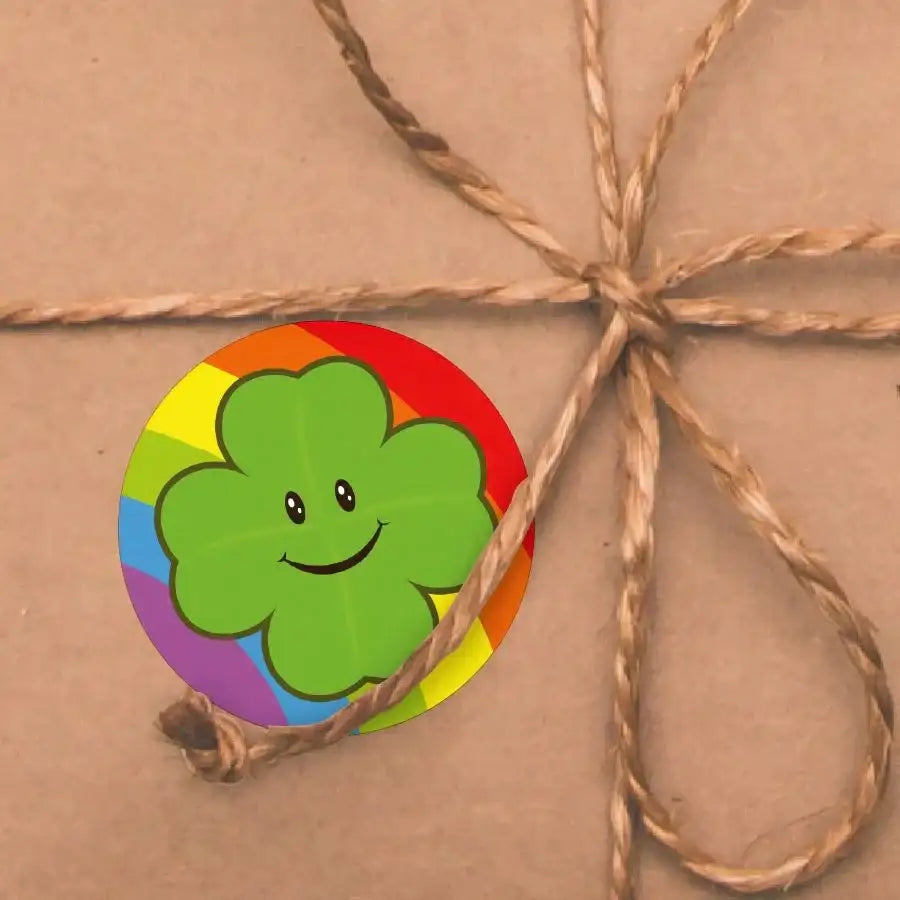 Smiling four-leaf clover reward sticker with rainbow border on brown gift wrapped with twine