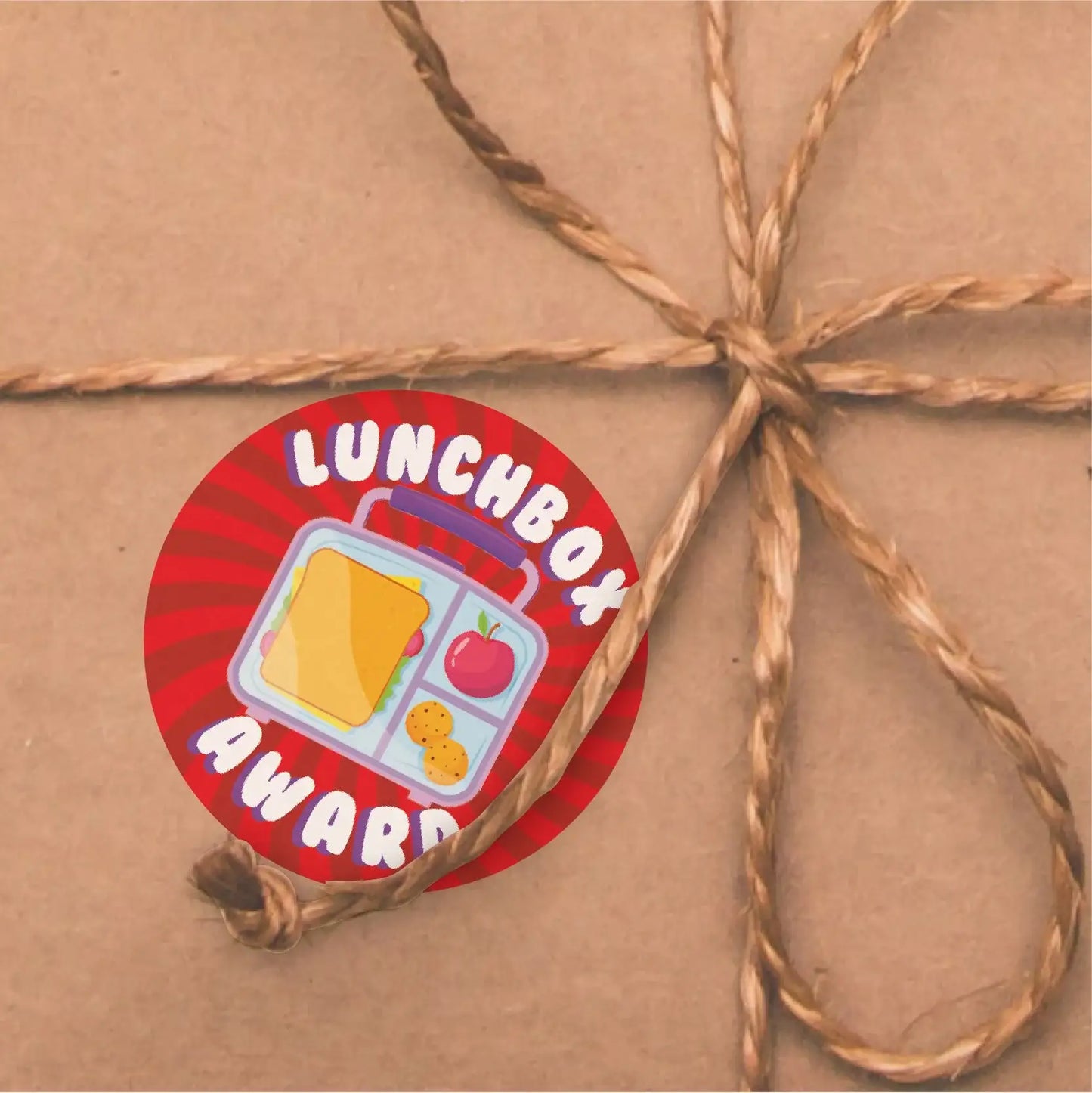 Lunchbox Award sticker with sandwich, apple, cookies on wrapped package, reward sticker