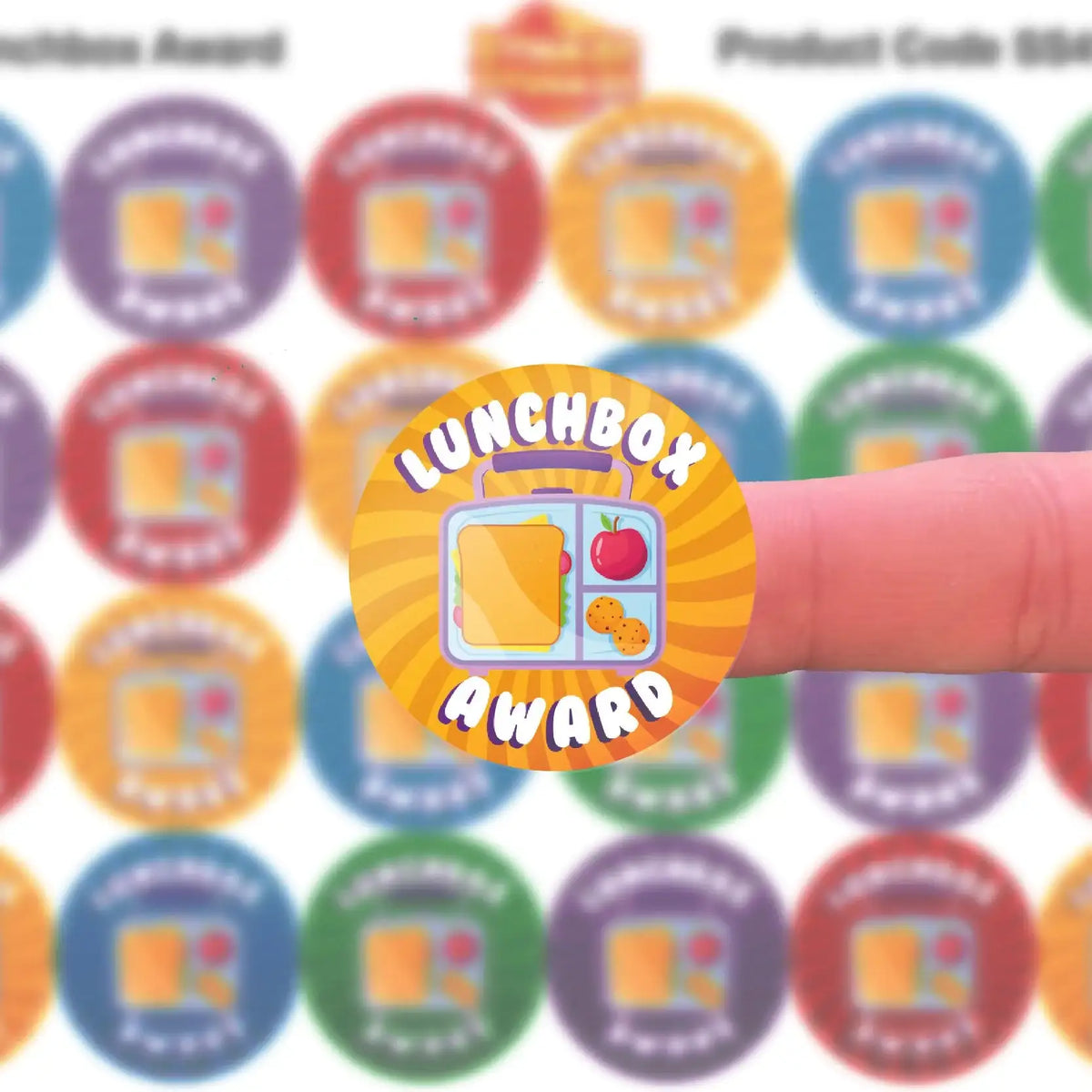 Colorful lunchbox award sticker for students on a finger, with assorted stickers in background