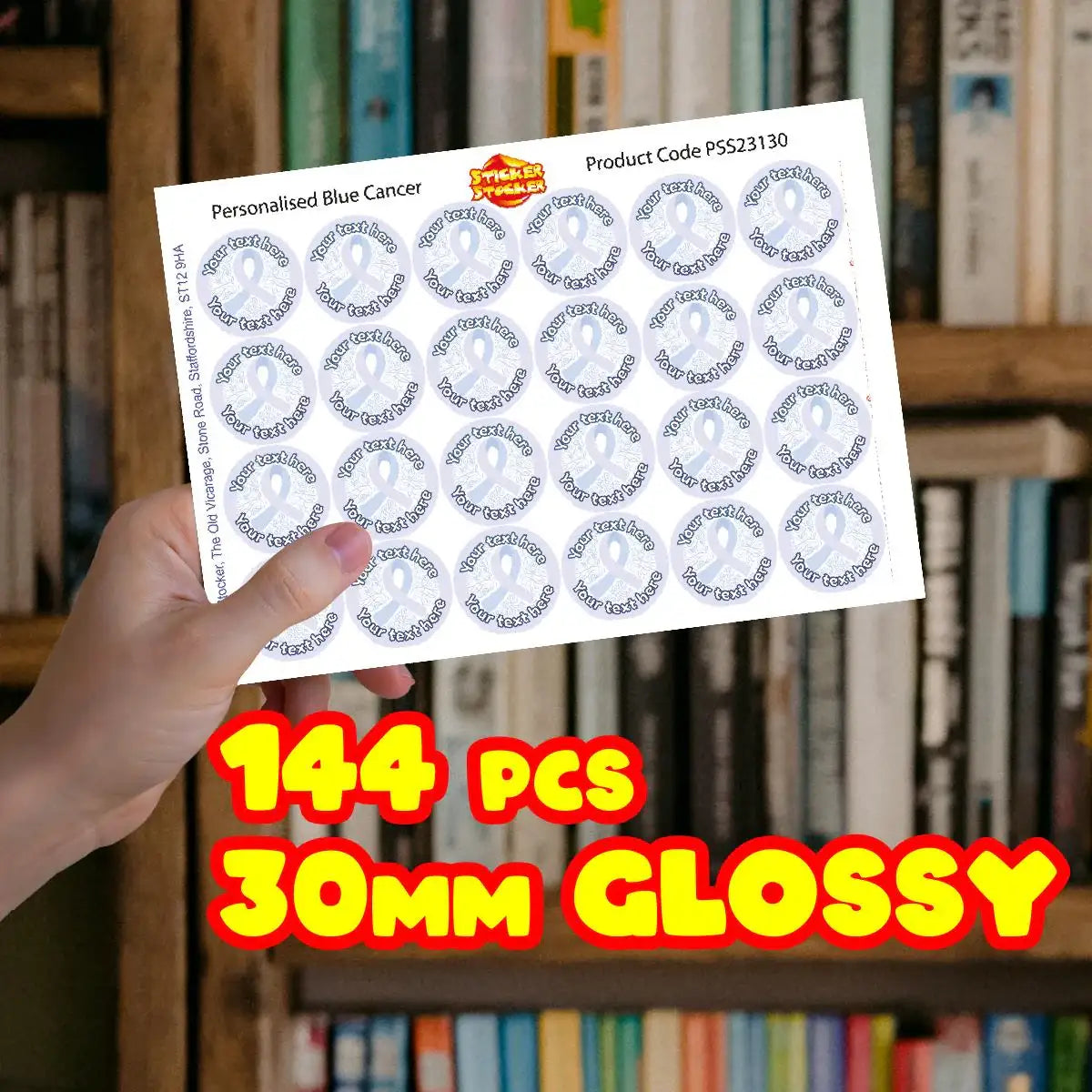 Hand holding sheet of 30mm glossy blue ribbon stickers, set of 144, in front of bookshelf.